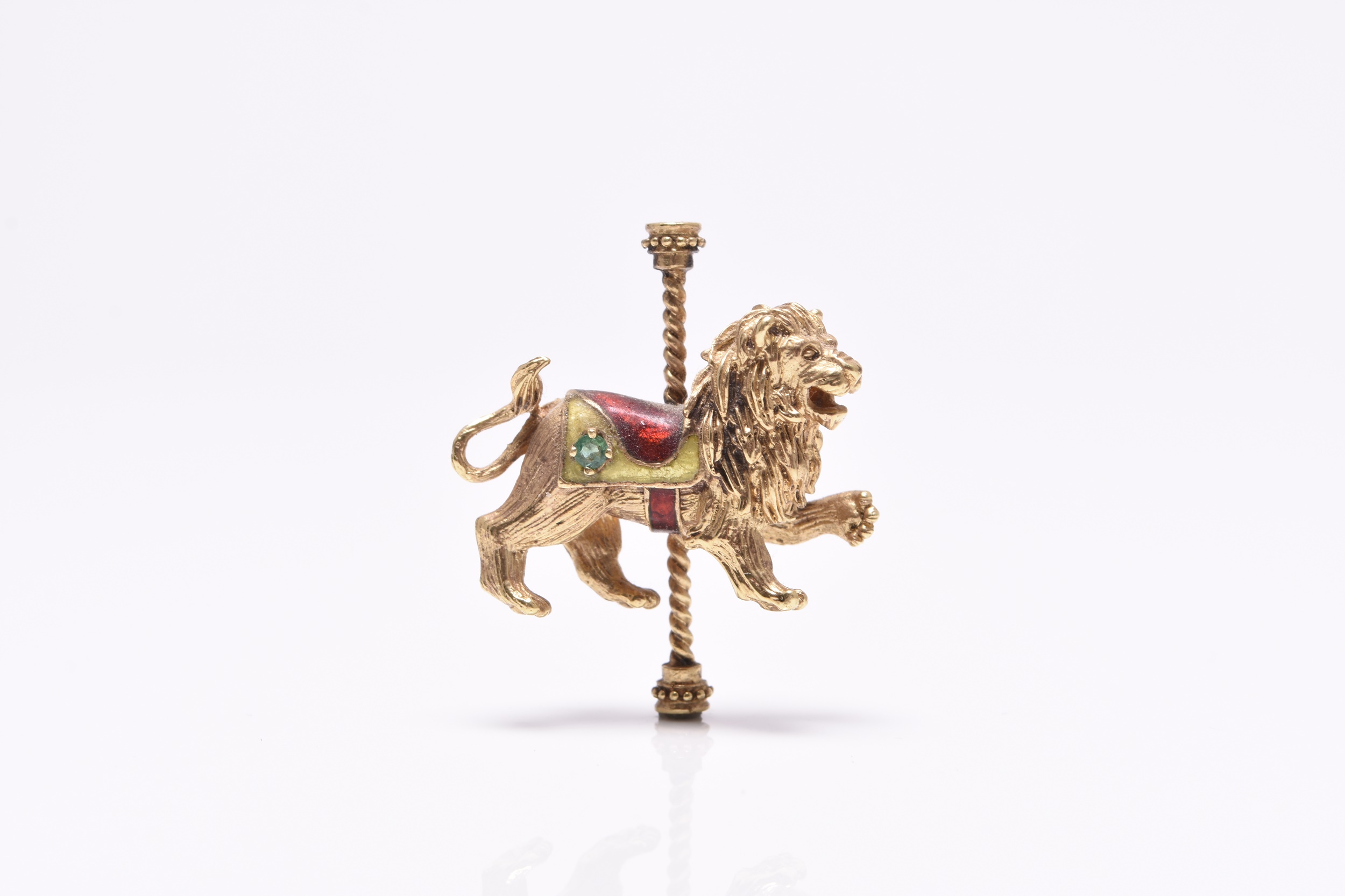 Lot 193 15/05/2024- An emerald and enamel brooch in the form of a fairground lion carousel, sold for £340